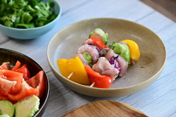 Close-up view of a raw chicken skewer prepared for roasting. Fresh pieces of chicken meat threaded...