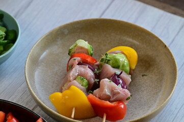 Close-up view of a raw chicken skewer prepared for roasting. Fresh pieces of chicken meat threaded...