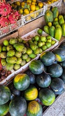 Fresh tropical fruits of watermelon, mangoes, dragon fruit and papaya at fruit and vegetable market stall in Bali Indonesia