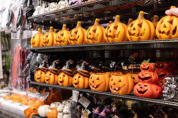 Retail display shelves packed with vibrant Halloween pumpkin decorations, featuring classic...