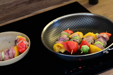 Grilled Chicken Skewer with Vegetables on Frying Pan at Home Kitchen with Induction Stove