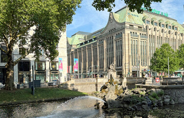 This fountain depicting the Greek god Triton sits in a Dusseldord city canal surrounded by shops & cafes