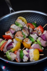 Grilled Chicken Skewer with Vegetables on Frying Pan at Home Kitchen with Induction Stove