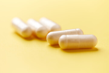 Collagen capsules. Bright paper background. Soft focus. Close up. Copy space.	