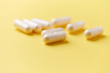 Collagen capsules. Bright paper background. Soft focus. Close up. Copy space.	