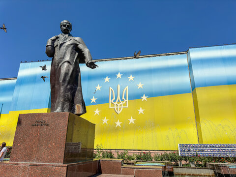 Monument to Taras Shevchenko in Chernivtsi, Ukraine, with a large Ukrainian flag mural featuring the trident coat of arms and EU stars behind