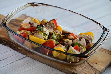 Chicken skewers with savory sauce in a glass baking dish, fresh from the oven. A delicious homemade...