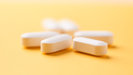 Magnesium tablets on bright paper background. Soft focus. Close up. Copy space	