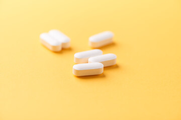 Magnesium tablets on bright paper background. Soft focus. Close up. Copy space	