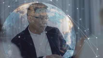 Male executive listening and reviewing document in business meeting, with globe showing network - Powered by Adobe