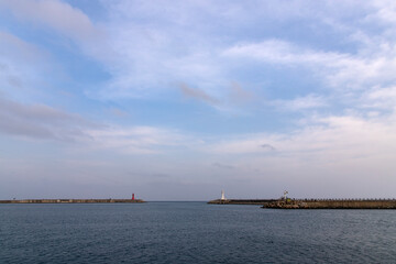 Obraz premium tranquil seascape with lighthouse on the seawall at the harbor
