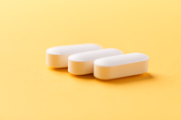 Magnesium tablets on bright paper background. Soft focus. Close up. Copy space	