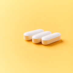 Magnesium tablets on bright paper background. Soft focus. Close up. Copy space	