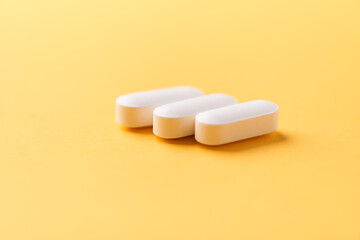 Magnesium tablets on bright paper background. Soft focus. Close up. Copy space	