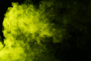 Hookah smoke in yellow light on black background, closeup