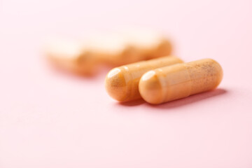 Vitamin B complex capsules on bright paper background. Soft focus. Close up. Copy space.