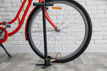 Bicycle and manual air pump indoors, closeup