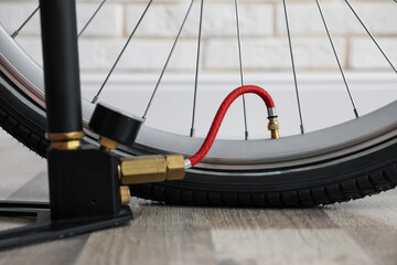Bicycle and manual air pump indoors, closeup