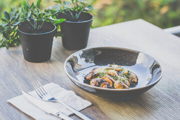 Sautéed Mushrooms with butter and herb served in a black dish