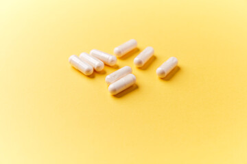 Collagen capsules. Bright paper background. Soft focus. Close up. Copy space.	
