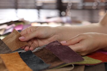 Woman choosing fabric among different samples indoors, closeup