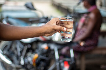 A man holding a glass of water in the market