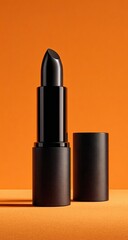 Obraz premium A black lipstick tube, closed and open, on an orange background