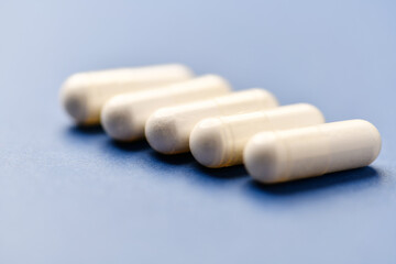 Arginine capsules on bright background. Soft focus. Close up. Copy space.	