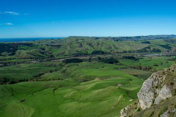 Obraz premium Lush Green Hills and Valleys Under Clear Blue Sky