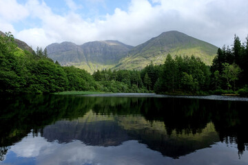 A still Torren Lochan, looking towards Bidean nam Bian mountains, Glencoe, Scotland, UK