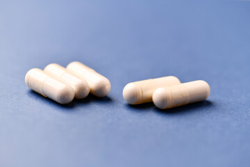 Arginine capsules on bright background. Soft focus. Close up. Copy space.