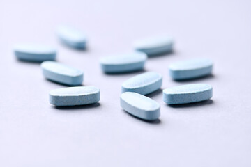 Multivitamin tablets on bright paper background. Close up. Copy space	