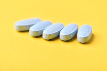 Multivitamin tablets on bright paper background. Close up. Copy space	
