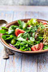 Healthy and tasty salad with tomatoes, olives, cucumber, and lettuce.