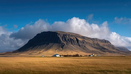 Dramatic mountain silhouette over a vast golden field