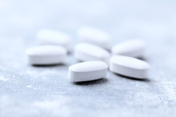 Amino acids tablets on wooden background. Soft focus. Close up