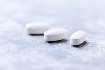 Amino acids tablets on wooden background. Soft focus. Close up