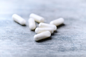 Beta-alanine capsules. Bodybuilding food supplements on wooden background. Soft focus. Close up. Copy space.	