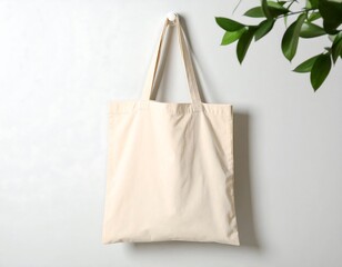 Blank eco-friendly tote bag for mockup. Empty reusable canvas shopping bag hanging on a wall for custom design and branding.