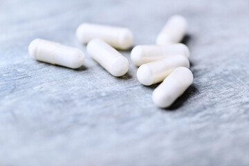 Beta-alanine capsules. Bodybuilding food supplements on wooden background. Soft focus. Close up. Copy space.	