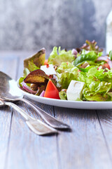 Healthy and tasty salad with feta cheese, tomatoes, olives, cucumber, onion and lettuce.	