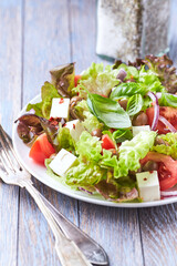 Healthy and tasty salad with feta cheese, tomatoes, olives, cucumber, onion and lettuce.	