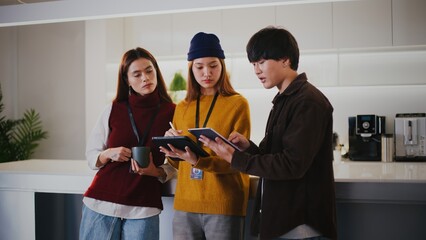 Focused diverse startup people including highschool student work together in modern office. young team collaborates with concentration using digital tablet