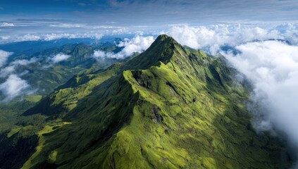 Lush mountain ridge piercing through a veil of clouds