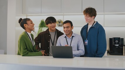 Happy diverse group of people including highschool student team working in modern office. Smiling young startup employees collaborating on project together