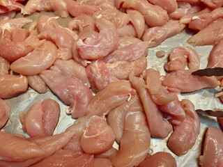 raw chicken fillets on a metal tray for sale 