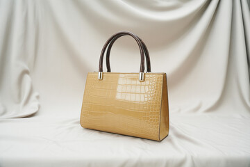 Luxurious beige handbag with crocodile pattern and brown handles on elegant background