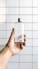 Mockup glass bottle in hand, clear plastic bottle, bathroom setting, modern design