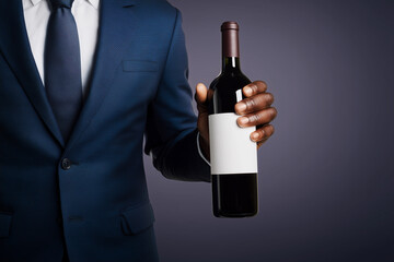 Mockup wine bottle in hand with blank label, dark red glass bottle, formal attire, sophisticated background