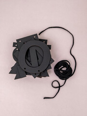Russian letters in a stack, letter o on top and black rope on a gray background